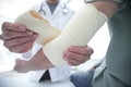 Orthopedist applying bandage onto patient`s hand in clinic Royalty Free Stock Photo