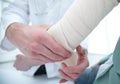 Orthopedist applying bandage onto patient`s hand in clinic Royalty Free Stock Photo