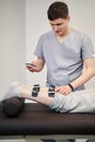 Orthopedist is clicking on muscle stimulator screen