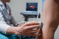 Orthopedist doctor doing ultrasound examination of patient& x27;s leg veins in his office. Young woman passing ultrasound Royalty Free Stock Photo