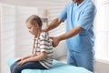 Orthopedist examining child`s back in clinic, closeup. Scoliosis treatment