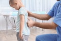 Orthopedist examining child`s back in clinic. Scoliosis treatment