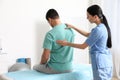 Orthopedist examining man`s back in clinic. Scoliosis treatment