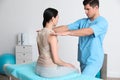 Orthopedist examining woman in clinic. Scoliosis treatment