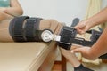 Orthopedist secures leg brace on knee, knee brace support for le Royalty Free Stock Photo