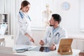 Orthopedists examining X-ray picture at desk in clinic