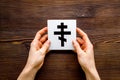 Ortodox cross in hands - Christianity symbol - on wooden background top-down Royalty Free Stock Photo