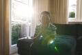 ortrait of african american boy thinking and sitting on couch in sunny living room