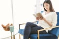 Ortrait Asian woman reading book and relaxing with coffee at home Royalty Free Stock Photo