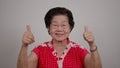 ortrait cheerful smiling Asian senior woman wear glasses grey hair over isolated white background and excited doing winner, clap