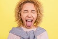 Ortrait of a girl that has closed her eyes and showing her tounge outside of the mouth. She is very funny. Isolated on