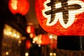 Closeup Black Japanese texts on red paper lantern hanging under Japanese restaurant eaves Royalty Free Stock Photo