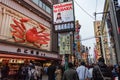 OSAKA, JAPAN - JAN 29, 2018: Tourists and locals walking on Osaka commercial street full of restaurant signs and a giant Crab