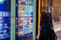 Chinese woman tourists looking and find restaurant at the terminal electronic map board