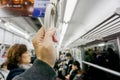 Closeup hand of human holding handle loop in a subway