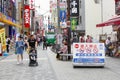 Osaka, Japan, May 2018, Father pushing child stroller and mother shopping Dotobori street