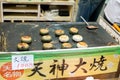 Mochi grill on hot pan with Japanese name and price label. One of tourist popular snack