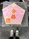 Female feet standing in front of a votive plaque Ema in Osaka