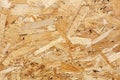 OSB boards are made of brown wood chips sanded into wooden background. Top view of OSB wood veneer background, tight Royalty Free Stock Photo