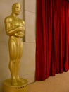 An Oscar statue at the Academy Awards next to a red curtain Royalty Free Stock Photo