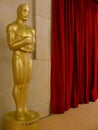 An Oscar statue stands next to a red curtain at The Academy Awards