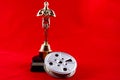 Oscar Statuette with Movie Reel on red