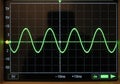 Oscilloscope display shows a sinusoidal waveform on a grid with labels. Vertical axis measures Royalty Free Stock Photo