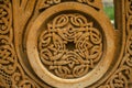 Round carved frame on a red stone with an ornament of intertwining strips forming a cross in the center