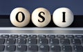 OSI - acronym on wooden balls on laptop keyboard background