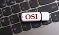OSI - the word on a white flash drive, lying on a black laptop keyboard