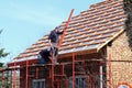 Osiek, Poland - april 18, 2018: Two builders are hiding a roof on a brick house in the village. Construction work on a small facil Royalty Free Stock Photo