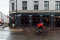 Blurry cyclist in motion riding in the rain in Grunerlokka, a trendy hipster neighborhood in central Oslo.