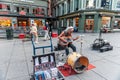 Oslo, Norway-August 1, 2013: a street musician performs on the main street of Karl Johans gate. An elderly man with long white