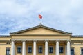 OSLO, NORWAY Ã¢â¬â JULY 11, 2022: Oslo, Norwegian Royal Palace, closeup of front of building with flag flying on top Royalty Free Stock Photo