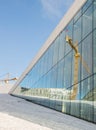 Oslo, Norway, March 16, 2018: Reflections of a crane in the windows of the Oslo Opera House in Bjorvika.