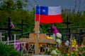 OSORNO, CHILE, SEPTEMBER, 23, 2018: Close up of selective focus of wooden cross with a small Chilean glag waving