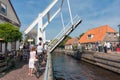 Pedestrians and bikers waiting for opened bridge for passing yachts