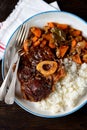 Osso buco beef stew with boiled rice in tomato sauce with onions, carrots, celery, garlic, rosemary and laurel leaves. Royalty Free Stock Photo