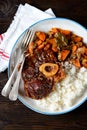 Osso buco beef stew with boiled rice in tomato sauce with onions, carrots, celery, garlic, rosemary and laurel leaves. Royalty Free Stock Photo