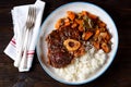 Osso buco beef stew with boiled rice in tomato sauce with onions, carrots, celery, garlic, rosemary and laurel leaves. Royalty Free Stock Photo