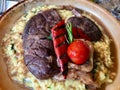 Osso Buco, Veal Shanks that are Braised in Wine with Saffron Risotto, Roasted Red Pepper and Rosemary.