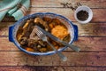 Ossobuco in cooking sauce with carrot, onion, bell pepper and mushrooms accompanied with sweet potato puree in a vintage a plate, Royalty Free Stock Photo