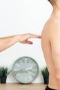 osteopath checks man& x27;s back with palm of his hand, young man stands