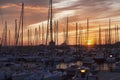 Beautiful harbor landscape at sunset, amazing orange sky with pastel-colored colors and sun resting at horizon between sails masts Royalty Free Stock Photo