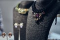 Necklaces with gemstones on a black jewelry bust in a store.