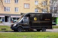 Dark brown Mercedes-Benz Sprinter van of UPS company on a street delivering a package for customers