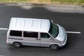 Silver Volkswagen Transporter T4 minibus driving on wet road with motion blur effect