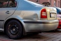 Slightly damaged rear side of a silver blue Skoda Octavia car after traffic accident in parking