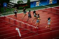 Female Sprinters Competing in 100m Hurdles Race: Track and Field Athletes Navigate Obstacles for