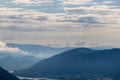 Oswaldiberg - A panoramic view on endless mountain chains in Austrian Alps. The mountains are shrouded in fog. A small village Royalty Free Stock Photo